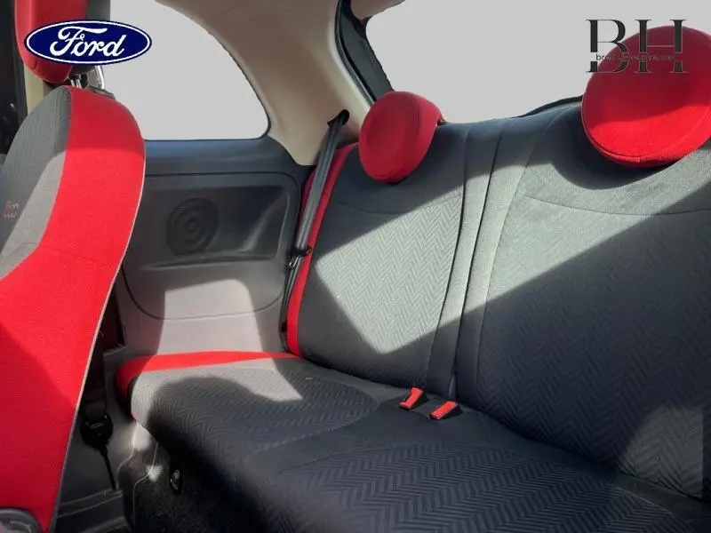 Vue intérieure arrière de la FIAT 500 2016, sièges noirs avec motifs Chevron et appuie-têtes ronds rouges.