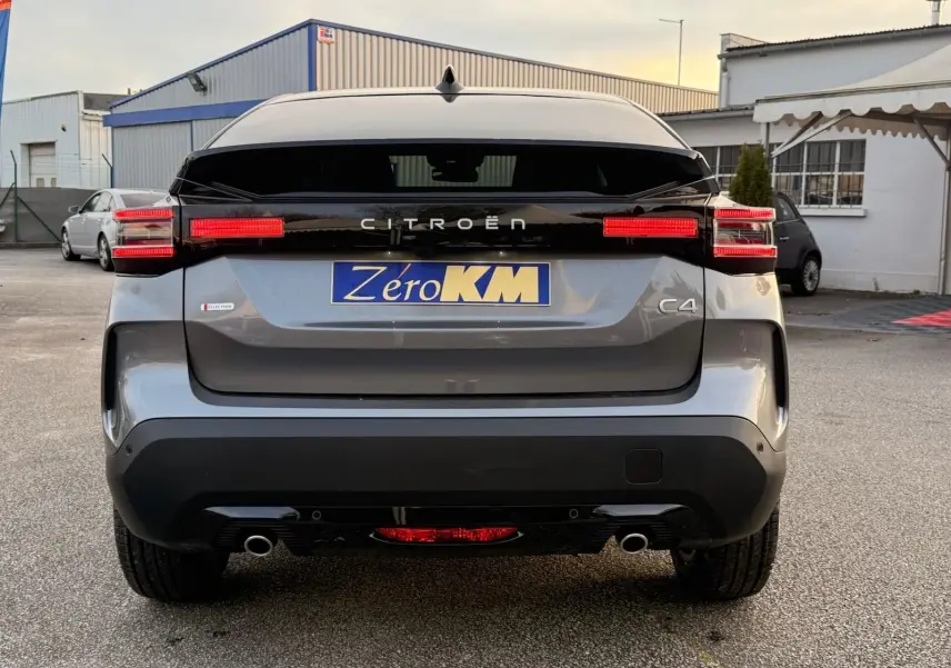 Vue arrière du Citroën C4 hybride gris Mercury avec feux LED allumés et logo distinctif sur le hayon.