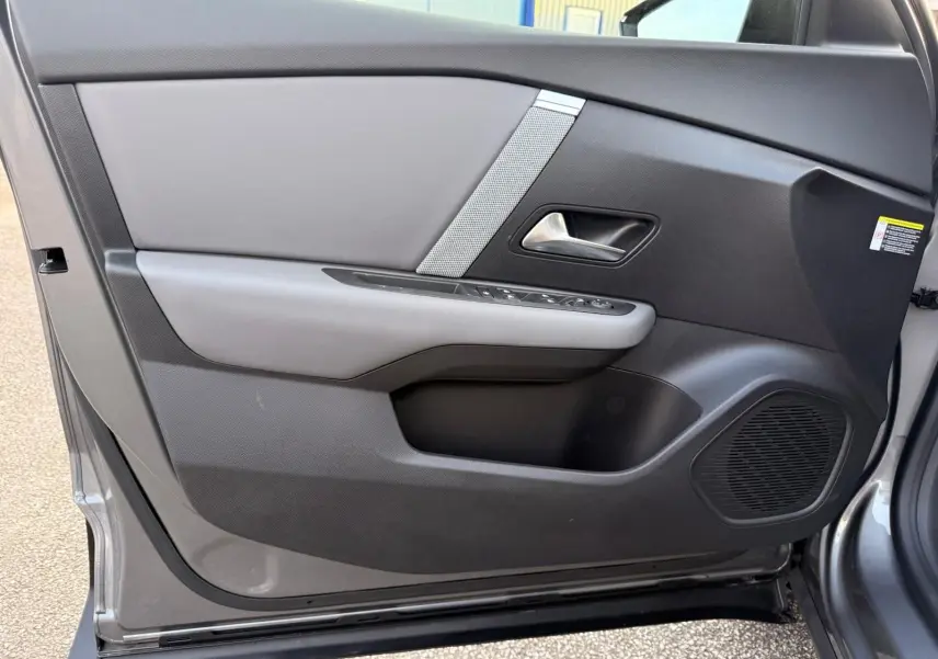 Vue intérieure côté gauche de la porte avant grise Mercury de la Citroën C4 hybride avec commandes et haut-parleur intégrés.