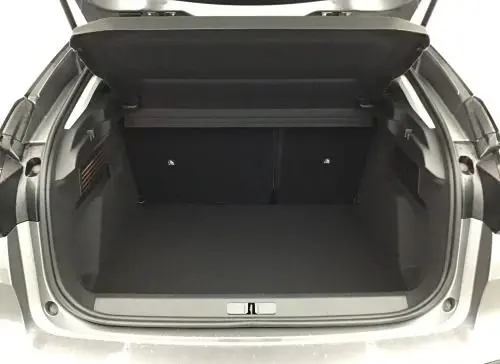 Coffre ouvert vu de l'arrière d'une Citroën C4 hybride 2025 gris Mercury, montrant l'espace de chargement vide.