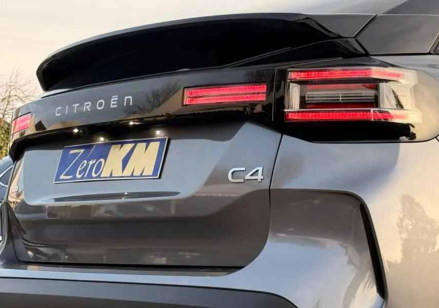 Vue 3/4 arrière droite d'une Citroën C4 gris Mercury avec feux arrière LED et logo distinctif sur hayon.
