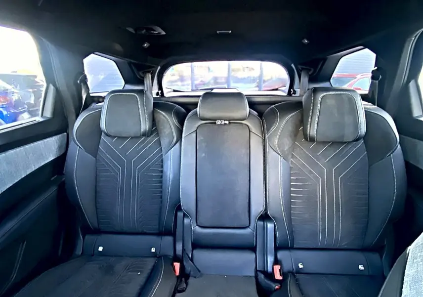 Vue arrière intérieure des sièges noirs du Peugeot 5008 Hybrid 145 GT avec appuis-tête et coutures contrastées.