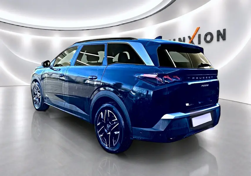 Peugeot 5008 noir vue 3/4 arrière droit dans un showroom lumineux avec jantes alliage noires.
