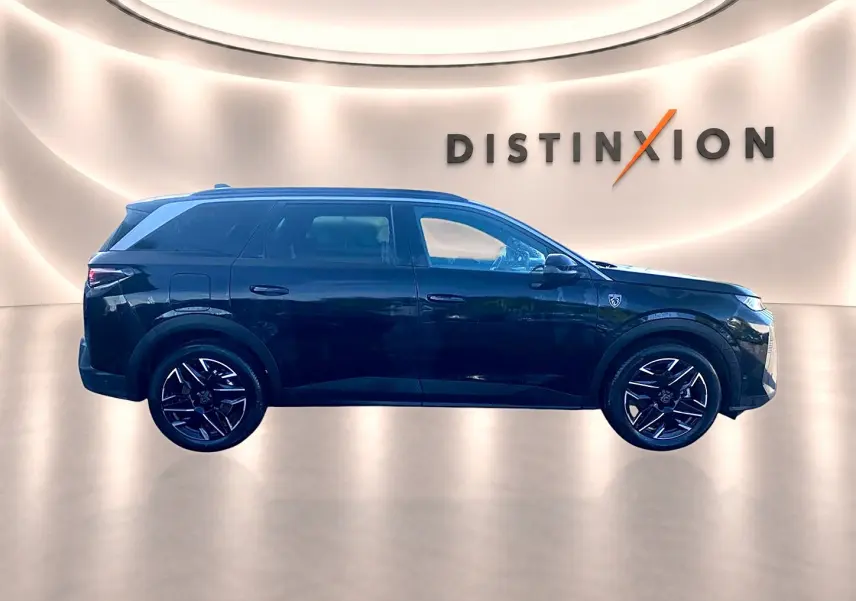 Profil droit du Peugeot 5008 noir 2025 avec jantes alliage et badge GT sur l'aile avant, en studio lumineux.