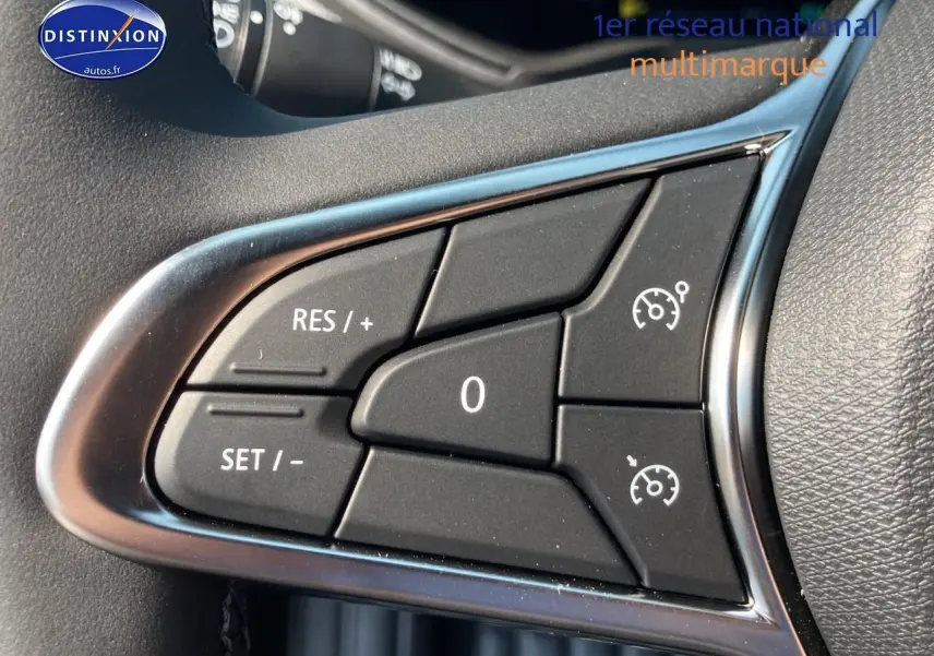 Gros plan sur les commandes de régulateur de vitesse au volant d'une Renault Clio V noire Étoile.