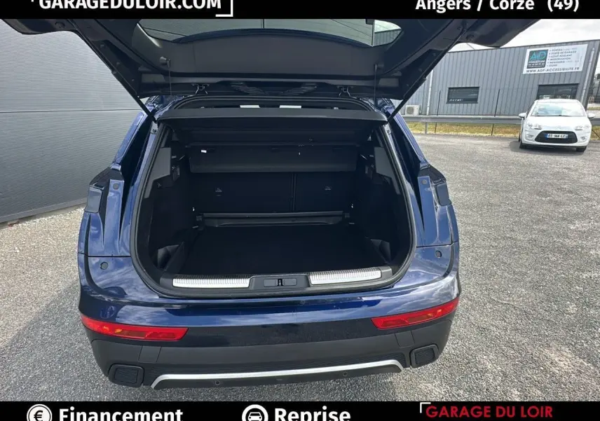 Vue arrière d'un DS7 bleu saphir avec coffre ouvert montrant un espace de chargement spacieux et un pare-chocs noir avec insert chromé.