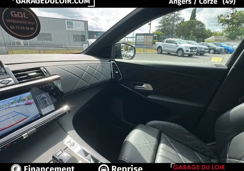 Intérieur côté passager du DS7 Bleu Saphir 2024, sellerie cuir noir et écran tactile avec caméra de recul visible.