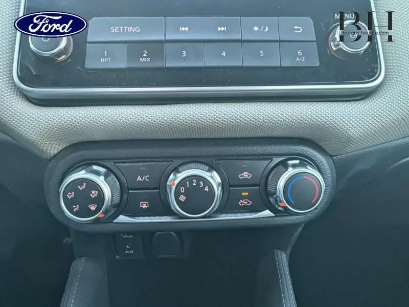 Tableau de bord de Nissan Micra 2018, vue centrée sur les commandes de climatisation manuelle avec réglages rotatifs.