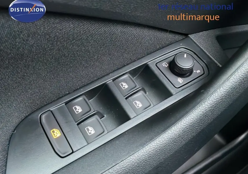 Gros plan sur les commandes de lève-vitres et réglage des rétroviseurs côté conducteur d’un Skoda Kamiq gris graphite.