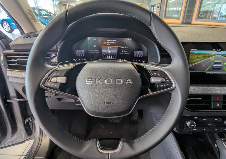 Vue centrée sur le volant cuir noir du Skoda Kamiq 2025 avec tableau de bord numérique et écran central tactile.