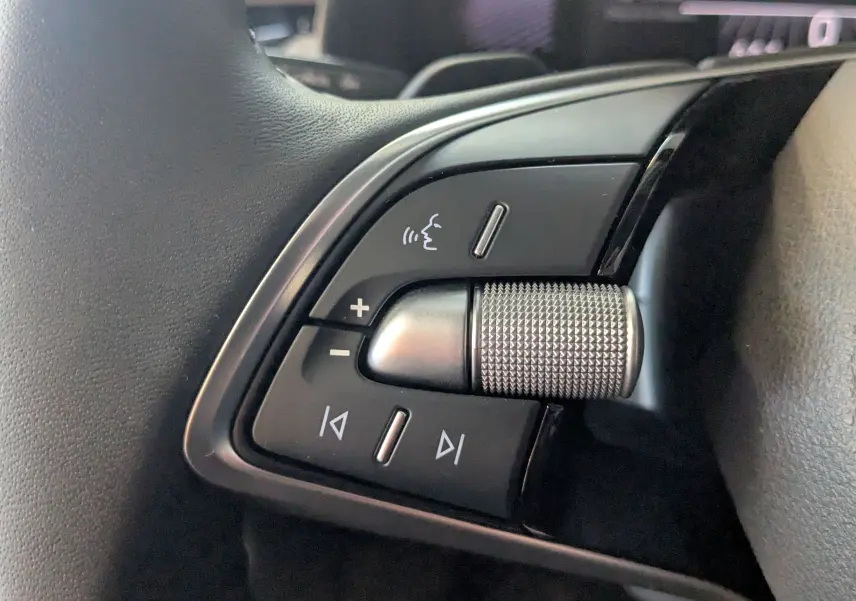 Gros plan sur les commandes noires et argentées au volant du Skoda Kamiq 2025, finition gris graphite métal.