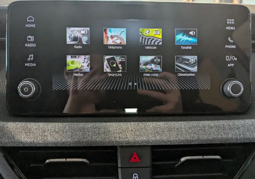 Écran tactile central du Skoda Kamiq 2025 en gris graphite, affichant les menus radio, téléphone, véhicule et climatisation.
