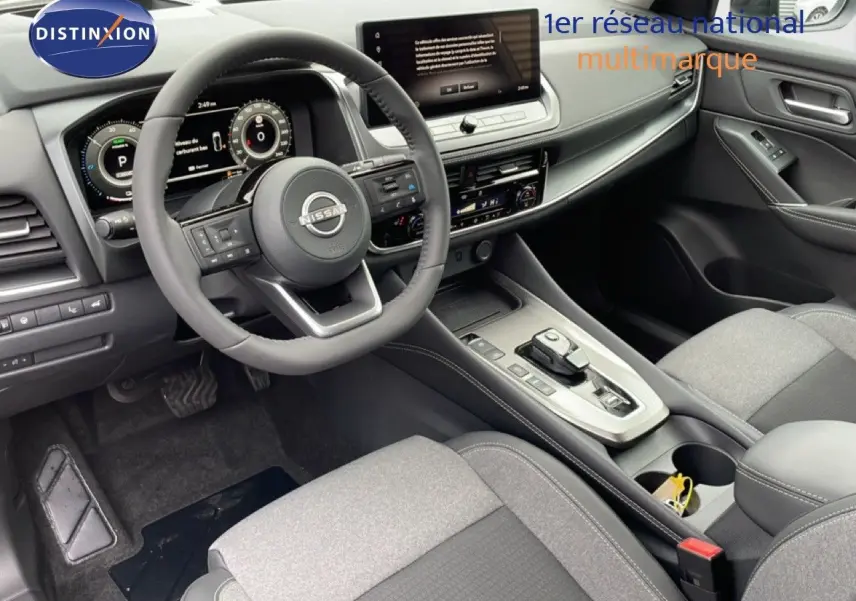 Intérieur du Nissan Qashqai 1.5 E-POWER 2025, vue côté conducteur, tableau de bord moderne gris et noir avec écran tactile.