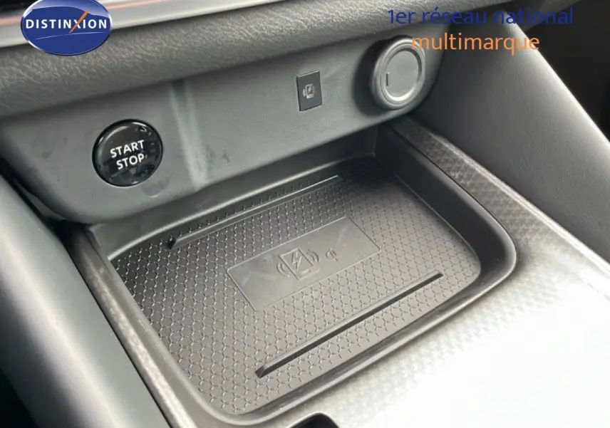 Détail de la console centrale du Nissan Qashqai 2025 montrant le bouton start/stop et un espace de recharge sans fil.
