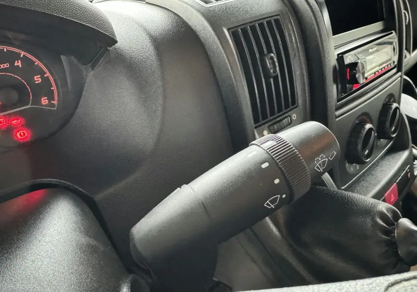 Gros plan sur la commande d'essuie-glace du tableau de bord noir du Citroën Jumper benne rouge 2019.