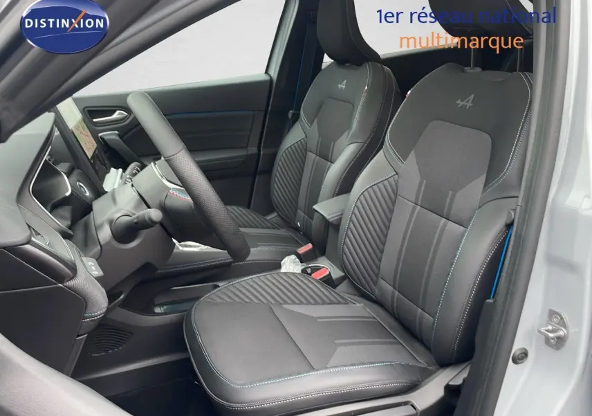 Vue intérieure côté conducteur de la Renault Symbioz E-Tech Full Hybrid 2025, sièges noirs avec surpiqûres bleues et logo Alpine.