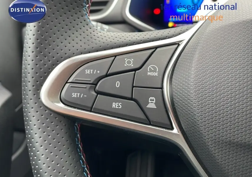 Gros plan sur les commandes au volant en cuir perforé noir du Renault Symbioz gris Rafale, version hybride 2025.