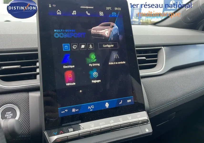 Vue intérieure centrée sur l'écran tactile du tableau de bord de la Renault Symbioz gris Rafale Métal, avec commandes climatisation visibles.