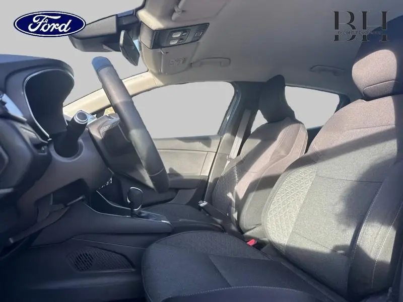 Intérieur avant de la Renault Clio gris Titanium, sièges tissu noir avec motifs surpiqués, vue côté conducteur.