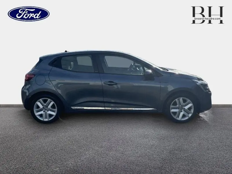 Profil côté gauche d'une Renault Clio 1.6 E-Tech hybride gris Titanium 2021 avec jantes alliage et poignées ton carrosserie.