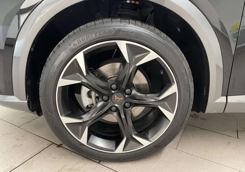 Gros plan sur la jante avant droite du CUPRA Formentor noir minuit, avec logo CUPRA et pneus Goodyear visibles.