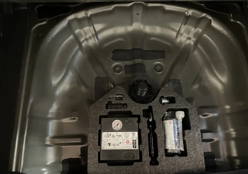 Gros plan sur le compartiment de roue de secours du CUPRA Formentor 2023 avec kit de réparation et outils intégrés.
