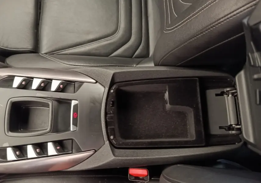 Vue plongeante sur la console centrale noire du DS5 2018, avec accoudoir ouvert et commandes électriques visibles.