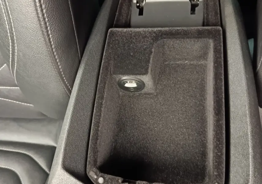 Vue rapprochée de l'accoudoir central ouvert en tissu noir dans une DS5 2018, avec prise USB visible.