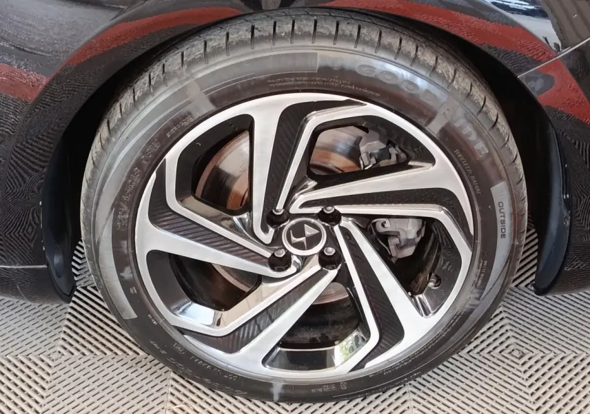 Gros plan sur la roue avant gauche noire d'une DS5 2018, jante alliage bicolore au design moderne.