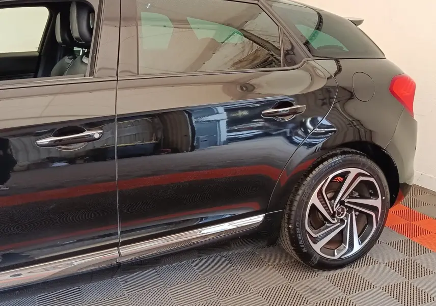 Vue latérale droite d'une DS5 noire 2018, mettant en valeur la jante alliage et les poignées chromées.