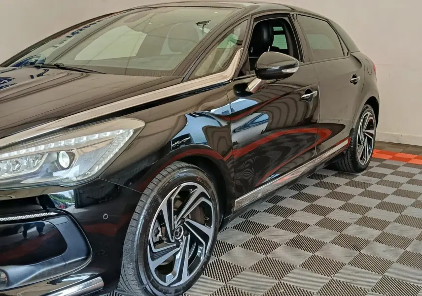 Vue 3/4 avant droit d'une DS5 noire brillante avec jantes alliage distinctives et rétroviseurs ton caisse électriques.