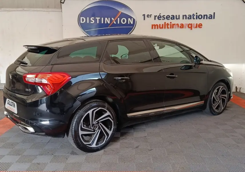 DS5 noir vue 3/4 arrière droit, jantes alliage distinctives et feux arrière LED visibles en intérieur showroom.