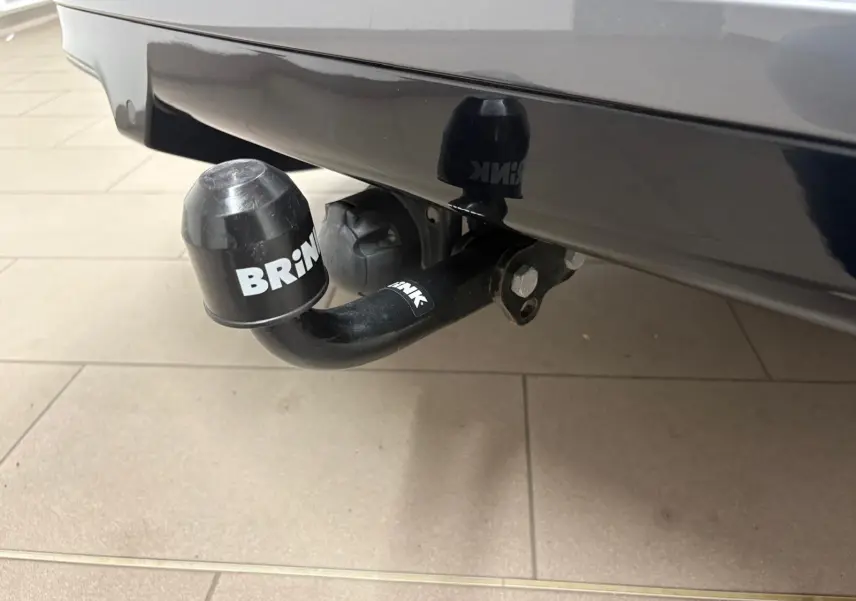 Gros plan sur l'attelage de remorque noir avec protection BRiNK sous le pare-chocs gris magnétique d'une CUPRA Formentor 2023.