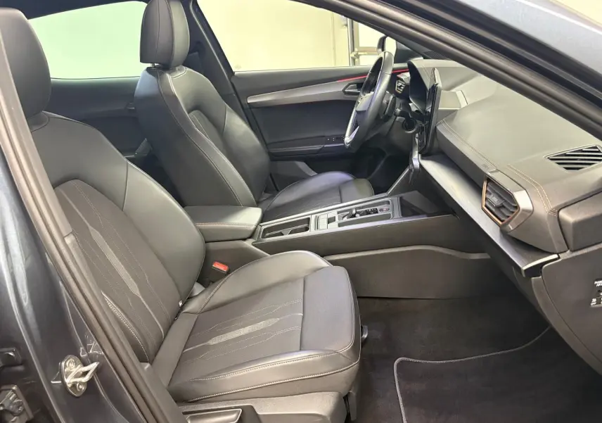 Intérieur avant droit du CUPRA Formentor 1.5 TSI 150 DSG7 VZ-LINE 2023 avec sièges cuir noirs et tableau de bord moderne.