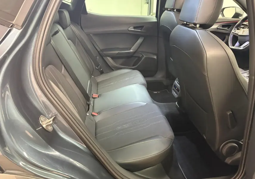 Vue intérieure côté gauche des sièges arrière en cuir noir du CUPRA Formentor gris magnétique 2023 avec détails de couture visibles.