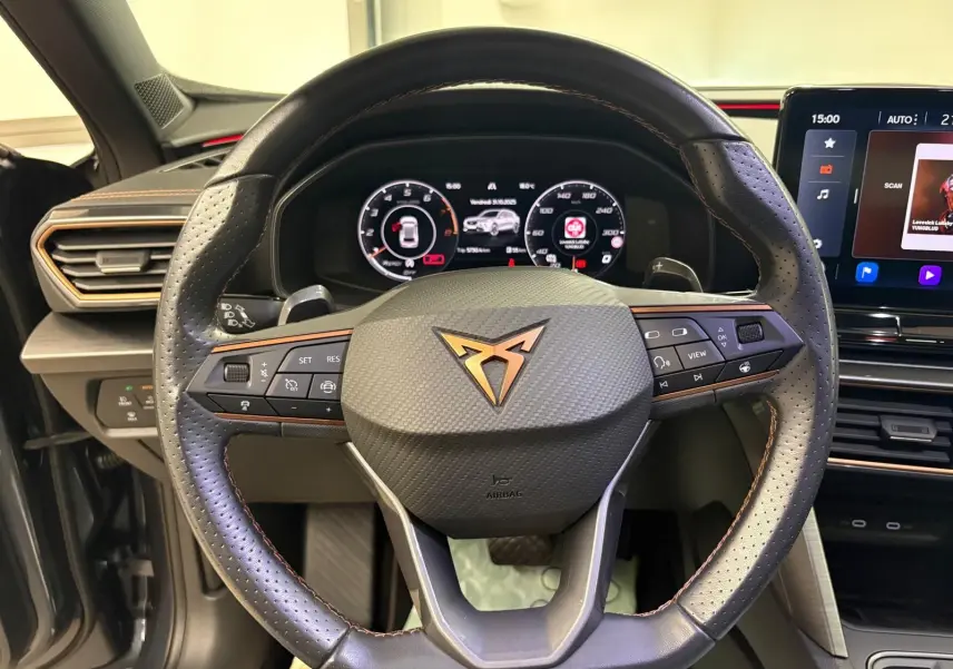 Volant en cuir perforé avec logo CUPRA cuivré, tableau de bord numérique et écran tactile dans l'habitacle du Formentor 2023.