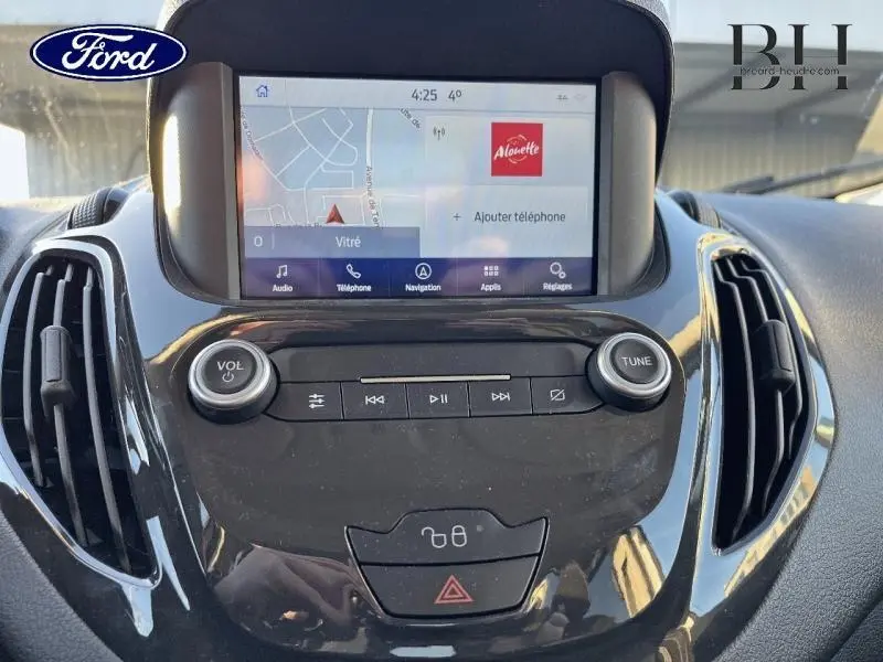 Vue rapprochée de la console centrale noire du Ford Tourneo Courier 2022 avec écran tactile GPS et commandes audio.