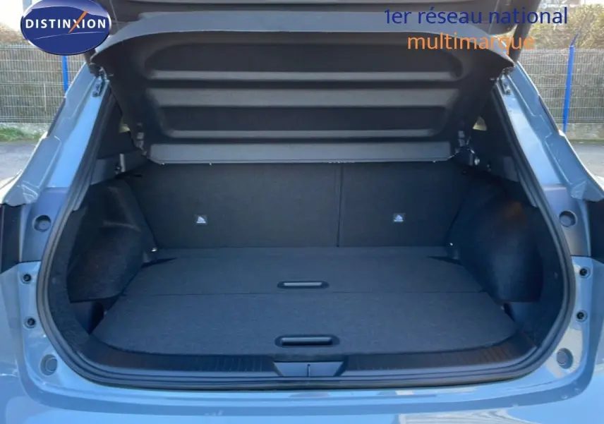 Coffre ouvert vu de l'arrière d'un Nissan Qashqai 2025 gris argile métal, montrant un espace de chargement spacieux.