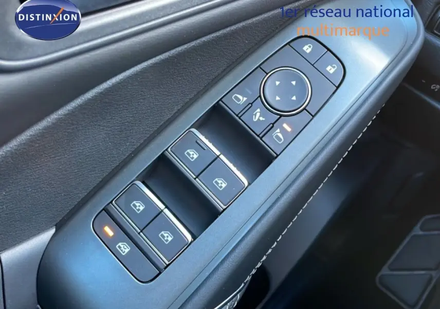 Gros plan sur les commandes des vitres et rétroviseurs côté gauche d’un Nissan Qashqai gris argile 2025.