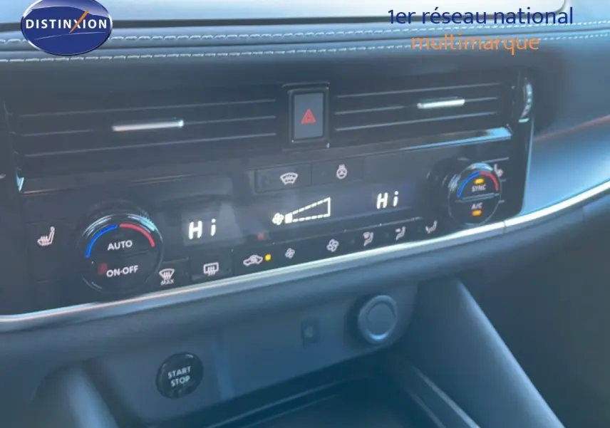 Détail du tableau de bord du Nissan Qashqai gris argile, montrant la console de climatisation digitale avec commandes tactiles.