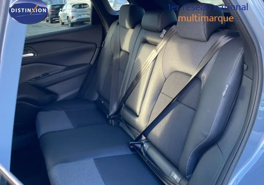 Vue intérieure côté droit montrant la banquette arrière en cuir et tissu noir du Nissan Qashqai gris argile métal 2025.