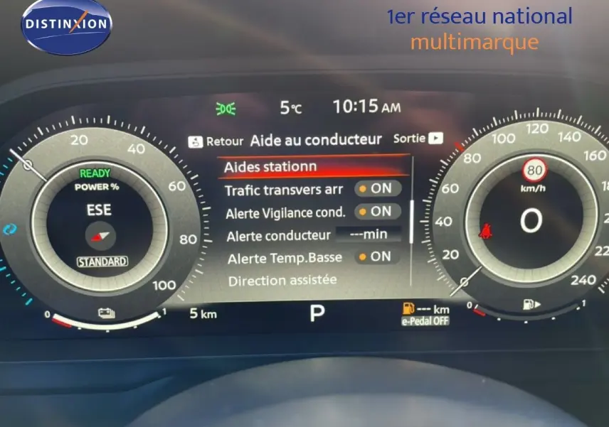 Vue de face du tableau de bord numérique du Nissan Qashqai gris argile métal 2025, affichant les aides à la conduite.