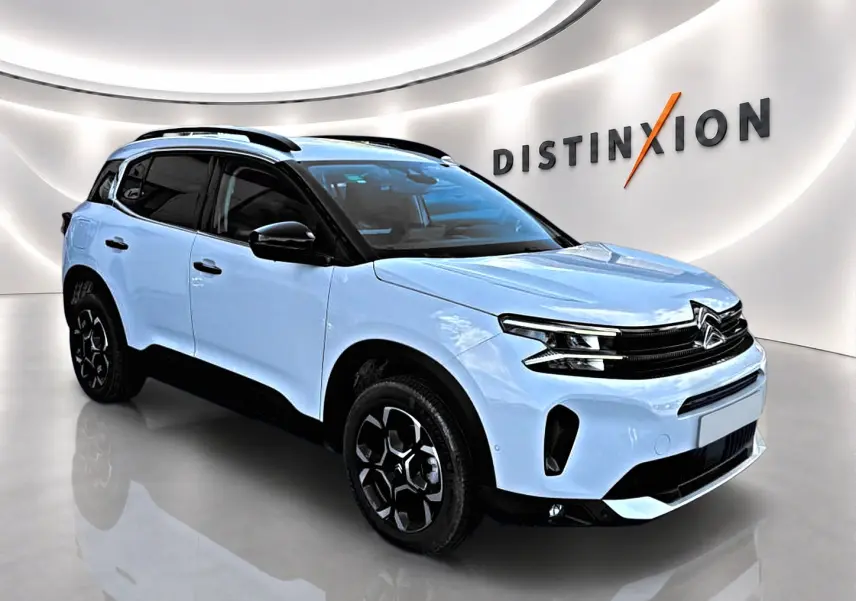 Citroën C5 Aircross blanc vue 3/4 avant droit avec toit noir et jantes alu distinctives en showroom.