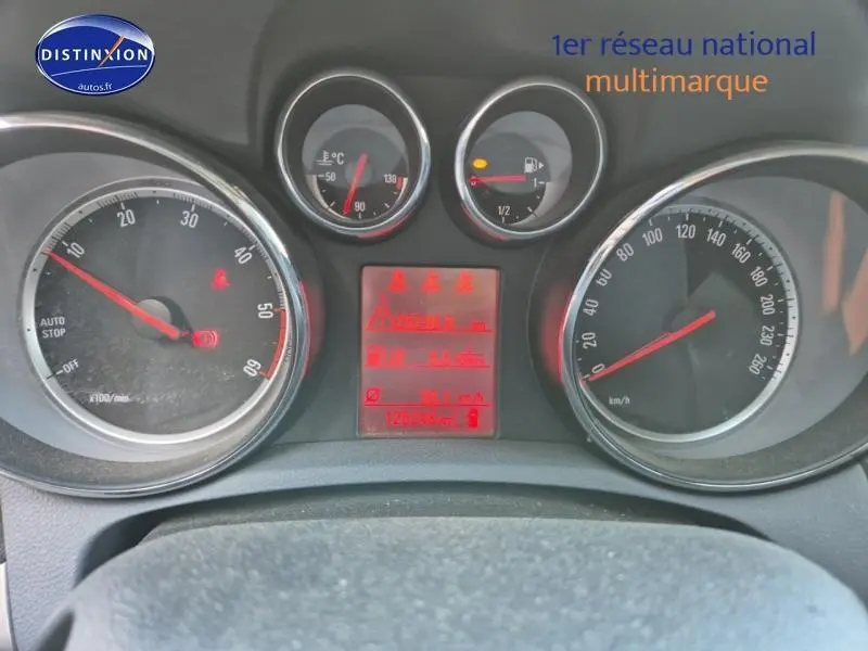 Vue rapprochée du tableau de bord de l'Opel Mokka 2016 avec compteurs ronds et affichage digital rouge.