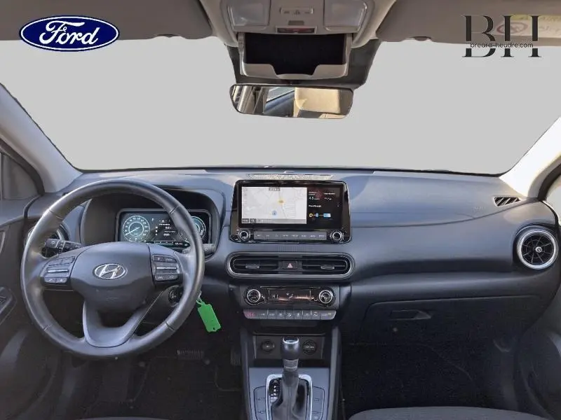 Vue intérieure frontale du tableau de bord noir du Hyundai Kona 1.6 GDi Hybrid 2022 avec écran tactile et volant multifonction.