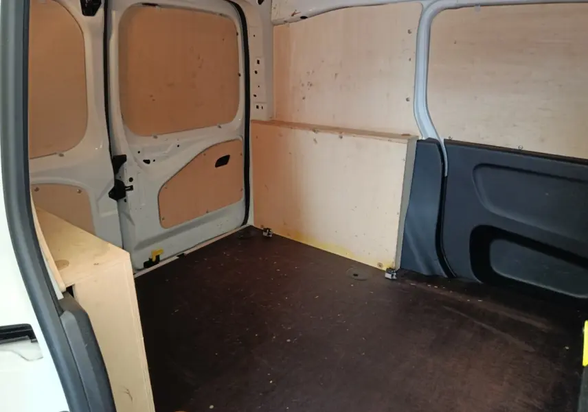Vue intérieure arrière du coffre blanc du Peugeot Partner 2022, avec cloison et panneaux en bois clair.