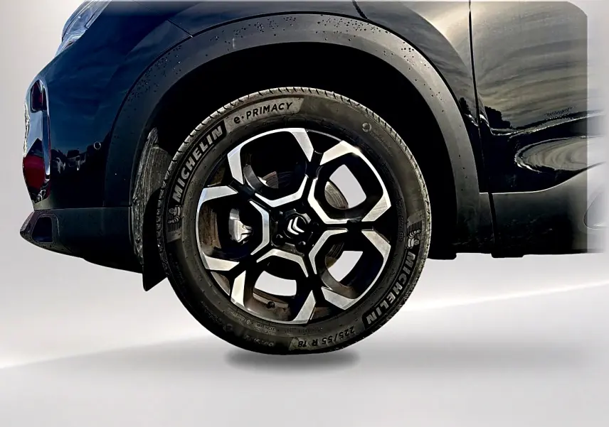Gros plan sur la roue avant gauche noire d’un Citroën C5 Aircross 2025 avec jante alu bicolore et pneu Michelin.