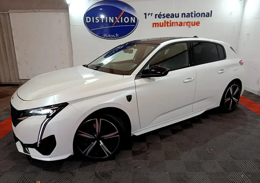 Peugeot 308 PHEV 180 GT blanc vue 3/4 avant droit, avec phares LED et jantes noires distinctives.