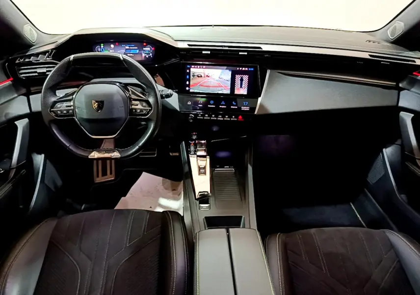 Intérieur de la Peugeot 308 PHEV 180 GT 2022, vue frontale du tableau de bord avec écran tactile et volant cuir noir.