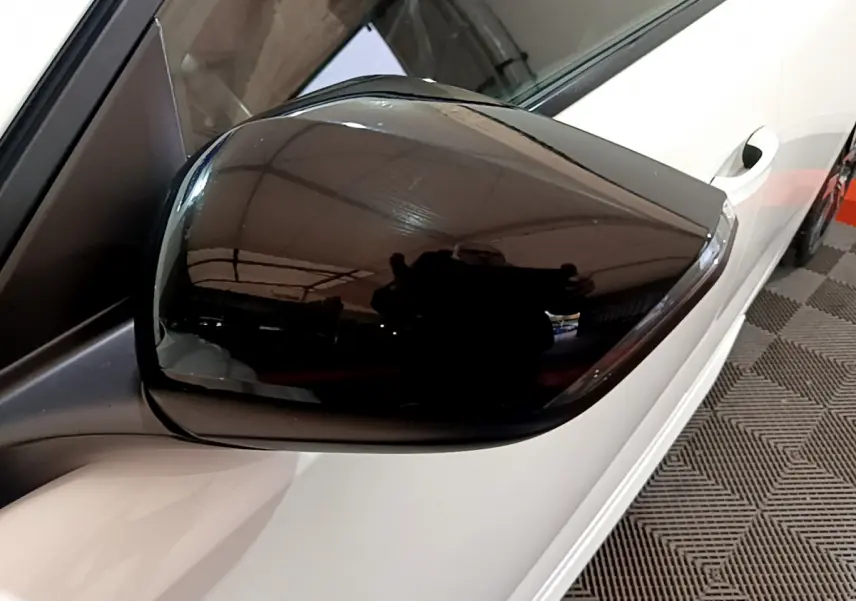 Rétroviseur noir côté gauche d'une Peugeot 308 PHEV 180 E-EAT8 GT blanche vue en gros plan depuis l'avant